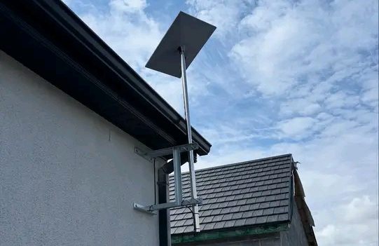  A Starlink Wi-Fi extended high above roof with a metal rod mounted on side of a house in Juba, South Sudan