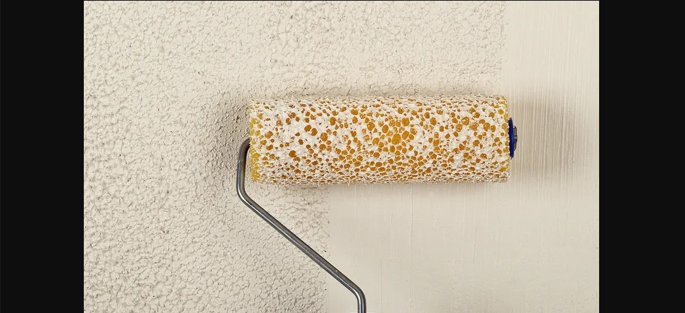 A brush applying a slightly rough texture on the wall