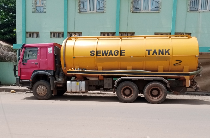 The side view of a yellow sewage truck in Juba