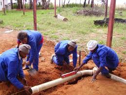 Four plumbers fixing underground pipes in Juba, South Sudan