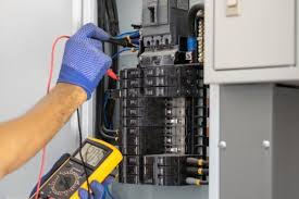 An electrician with a tester device testing power in a panel in Juba South Sudan