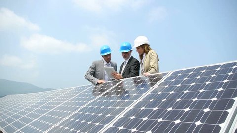 Three technicians on the roof besides solar panels in Juba South Sudan