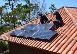 Two solar technicians on the roof fixing solar panels in Juba South Sudan